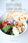 Bowl of cobb salad with pita and text overlay