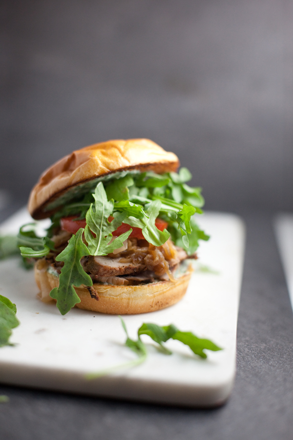 Pork Tenderloin Sandwich with lots of arugula on a cutting board