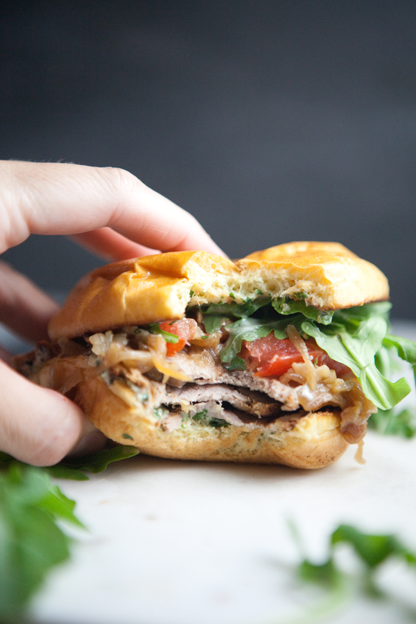 Pork Tenderloin Sandwich with lots of arugula on a cutting board