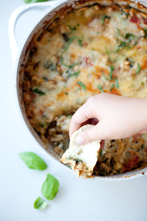 Dipping bread into cheesy spaghetti squash bake