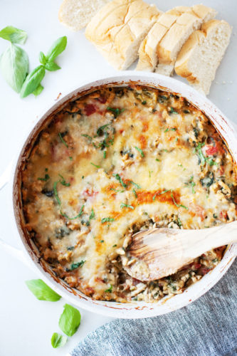 Cheesy spaghetti squash bake in one pan with a wooden spoon