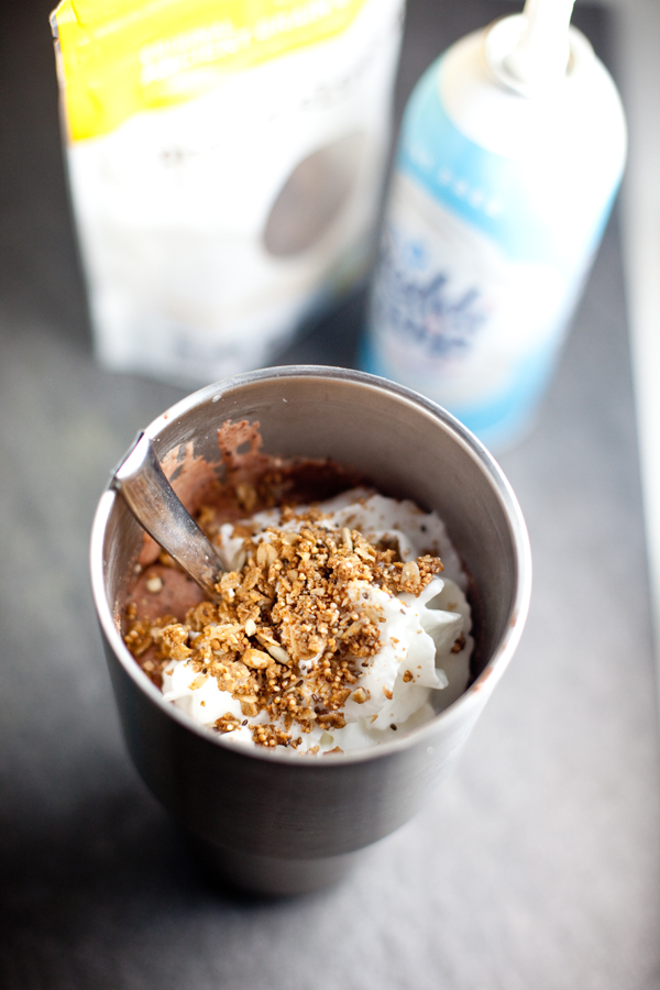 protein shake in a large metal tumbler with whipped cream and granola