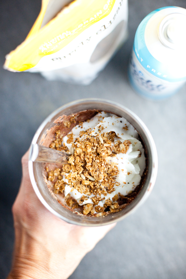 protein shake in a large metal tumbler with whipped cream and granola