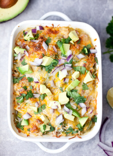 Spaghetti squash enchilada bake topped with avocado, cilantro, and onions