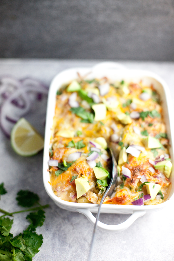 Spaghetti squash enchilada bake topped with avocado, cilantro, and onions