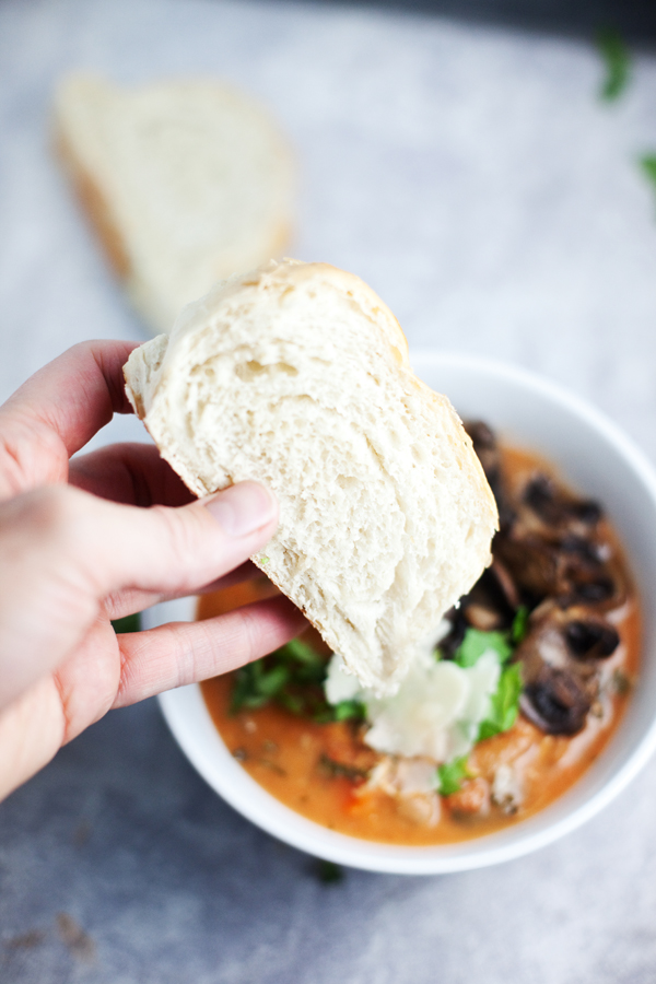 Dipping bread into a bowl of soup