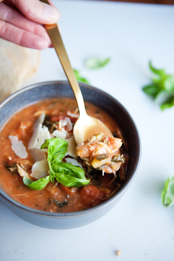 A bite of Creamy Tomato Chicken Soup in a bowl