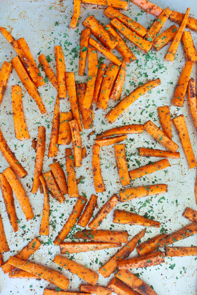 pan of Spicy Carrot Fries with Lemon Cumin Yogurt Sauce | macro friendly sides recipe by www.lillieeatsandtellscom.bigscoots-staging.com